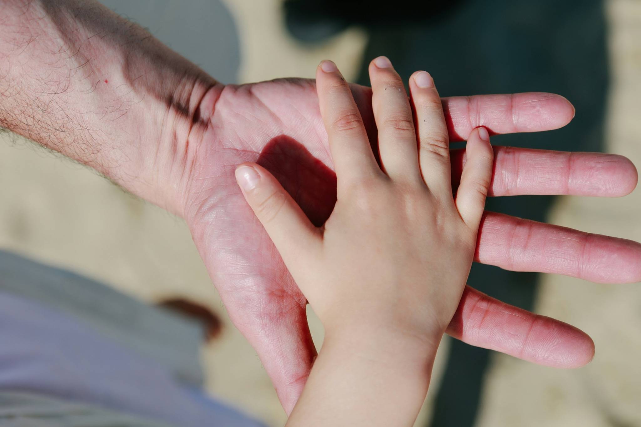 Child’s hand resting in an adult’s palm, symbolising the inner child, emotional safety, attachment, and therapeutic support in psychodynamic counselling.