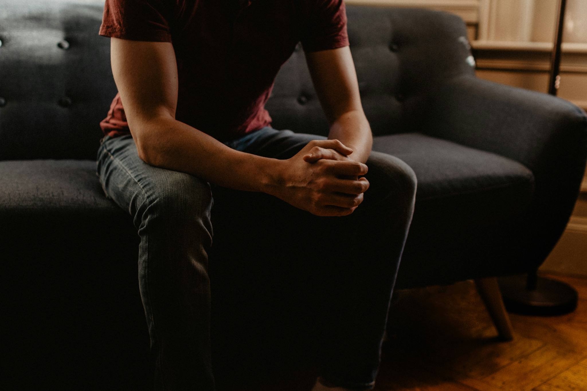 Person sitting thoughtfully on a sofa during a psychodynamic counselling session illustrating the value of therapy, emotional wellbeing and mental health support in Haywards Heath and Crowborough.